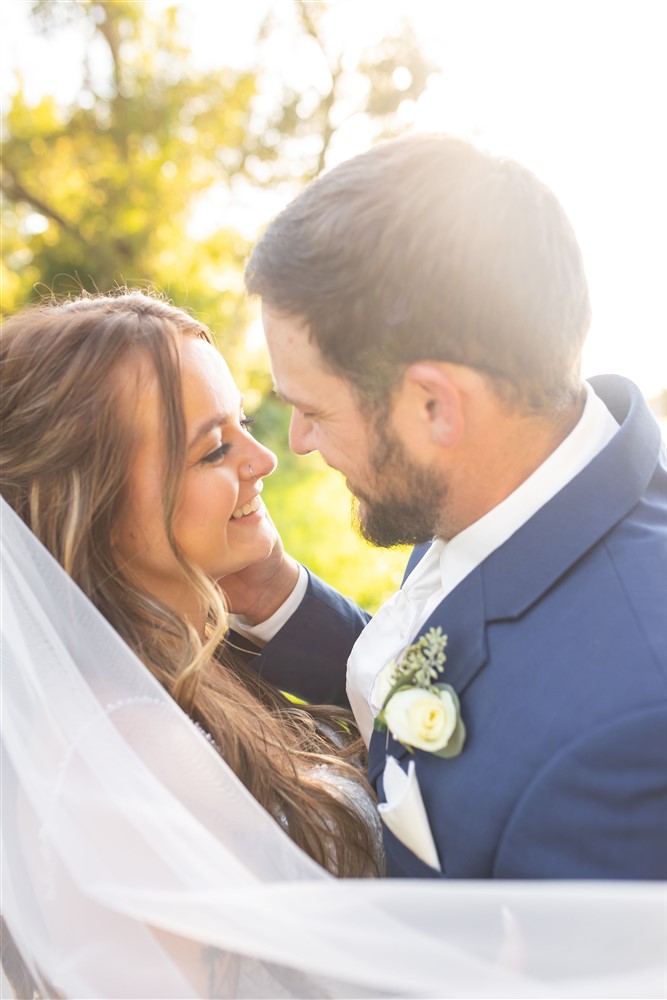 Bride and groom veil photo at the Farmhouse venue outside of Omaha with wedding photographer Cassie Burley