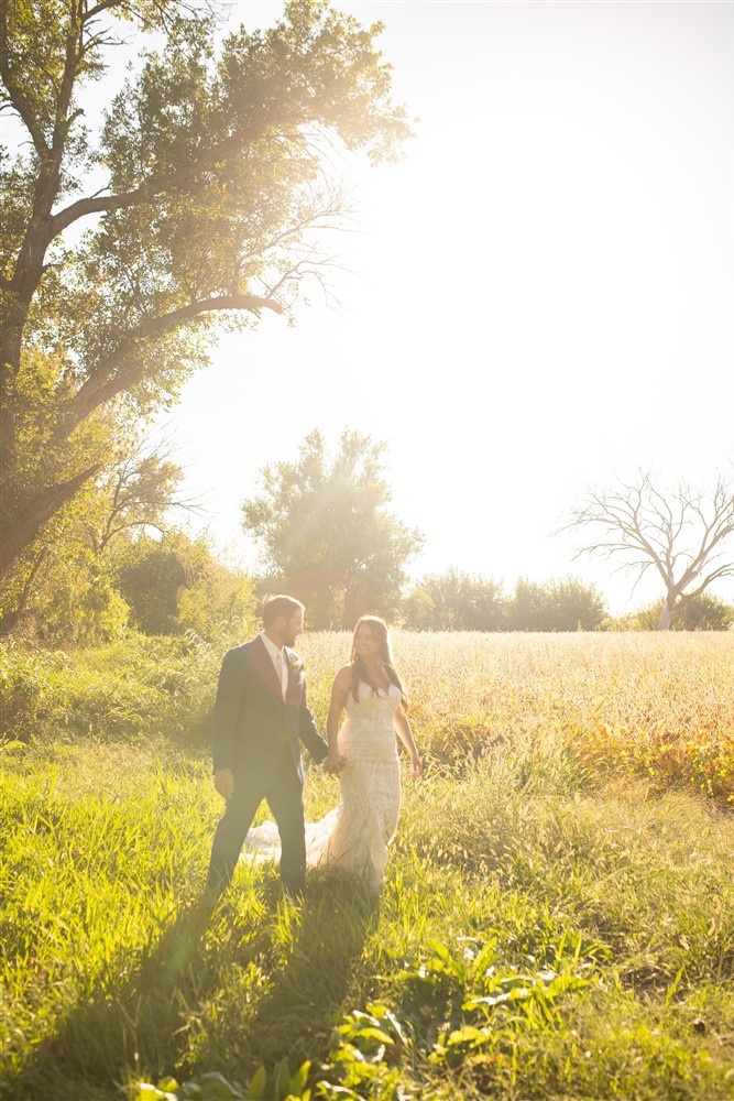 Bride and groom walking photo at the Farmhouse venue outside of Omaha with wedding photographer Cassie Burley