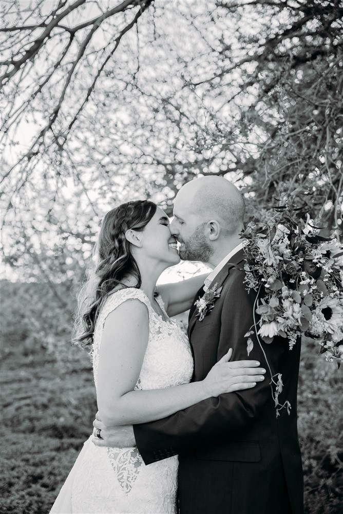 A wedding at Spark Barn a venue located right outside of Omaha, NE sharing a kiss with wedding photographer Erin Mitchell