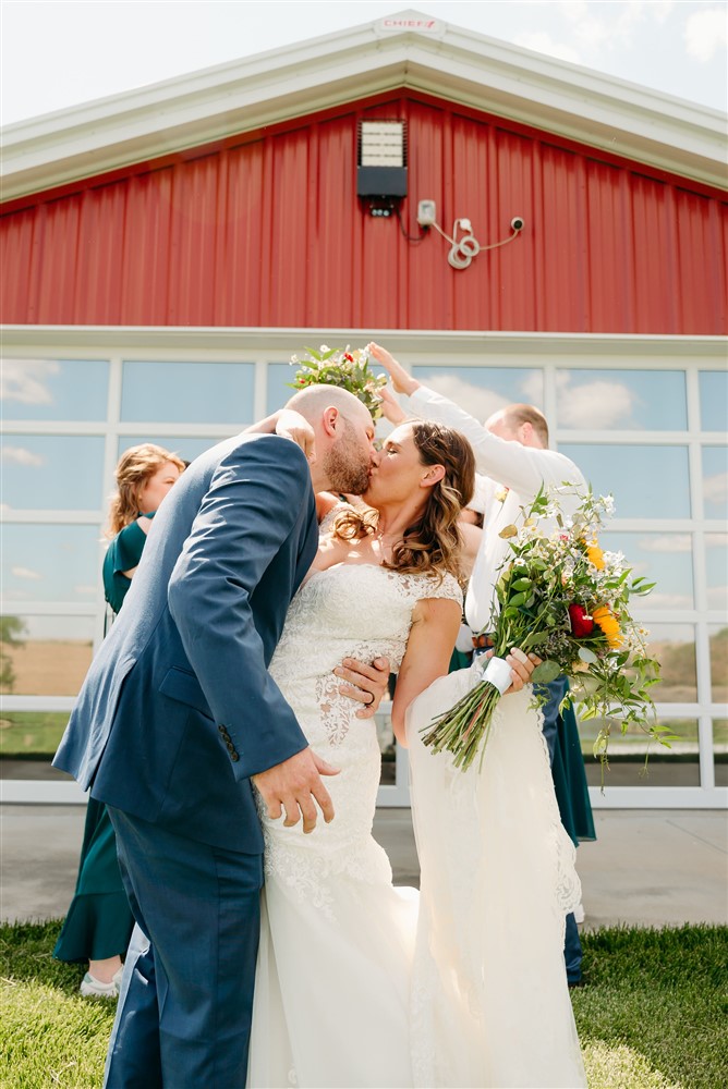 A wedding at Spark Barn a venue located right outside of Omaha, NE sharing a kiss with wedding photographer Erin Mitchell