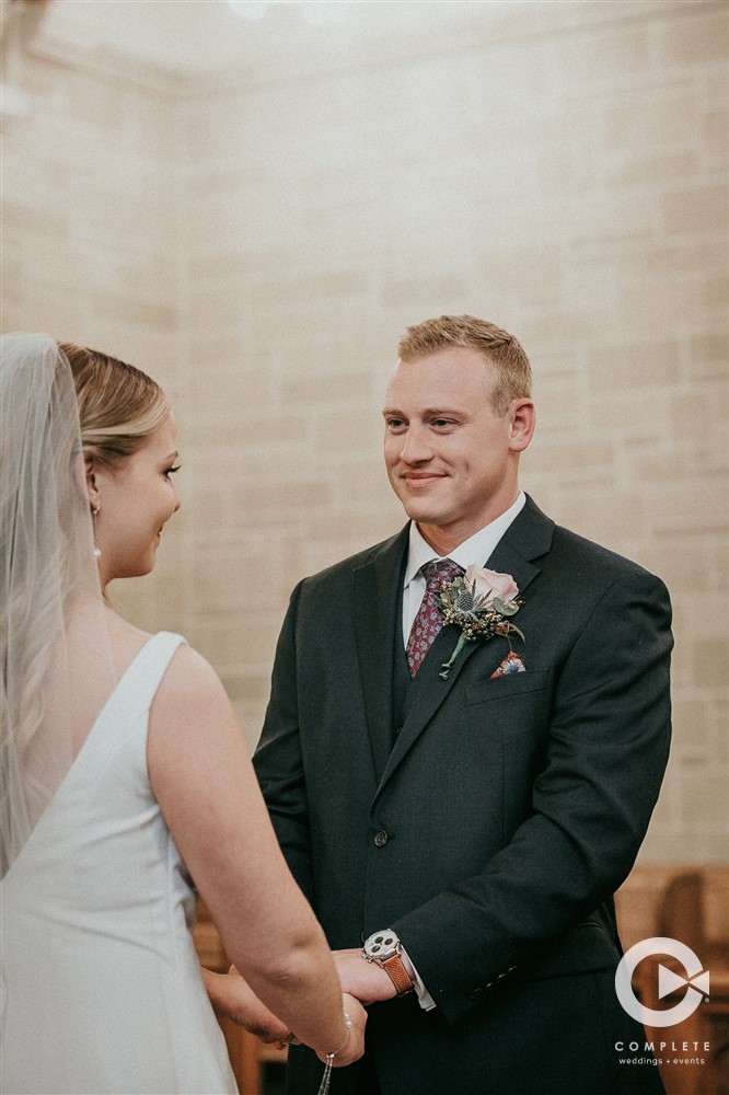 groom looks at bride during ceremony