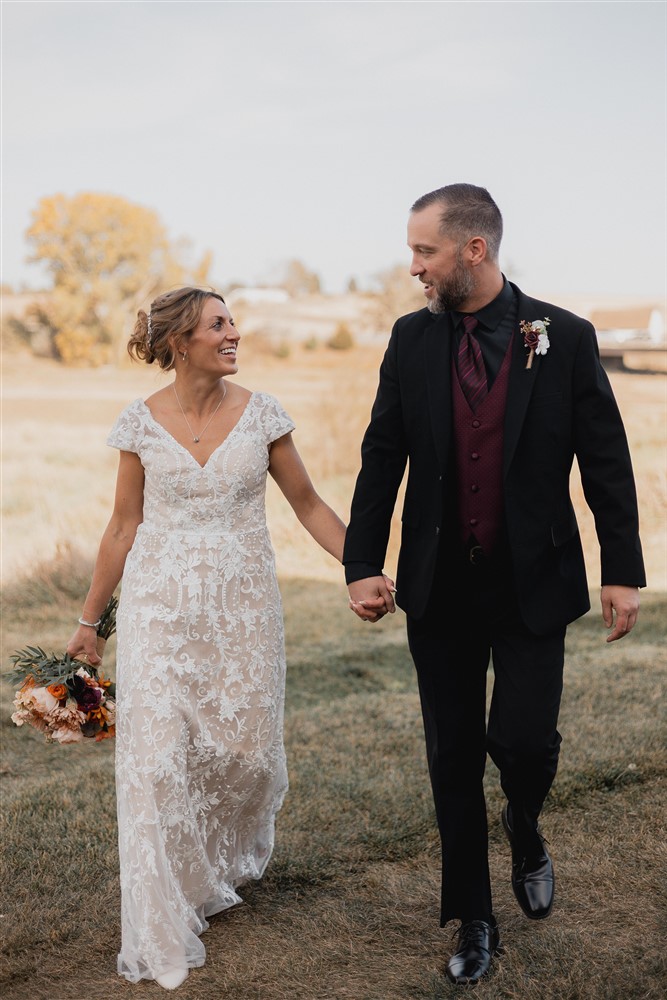 Bride and groom holding hands at Beardmore Event Center in Omaha, NE with photographer Ade Idowu