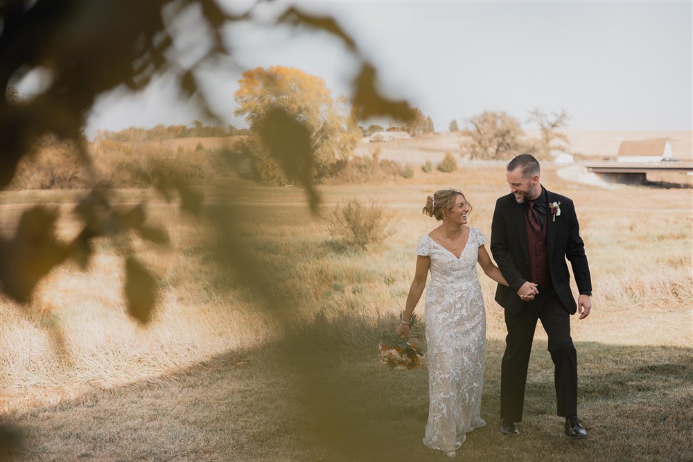 Bride and groom walking at Beardmore Event Center in Omaha, NE with photographer Ade Idowu