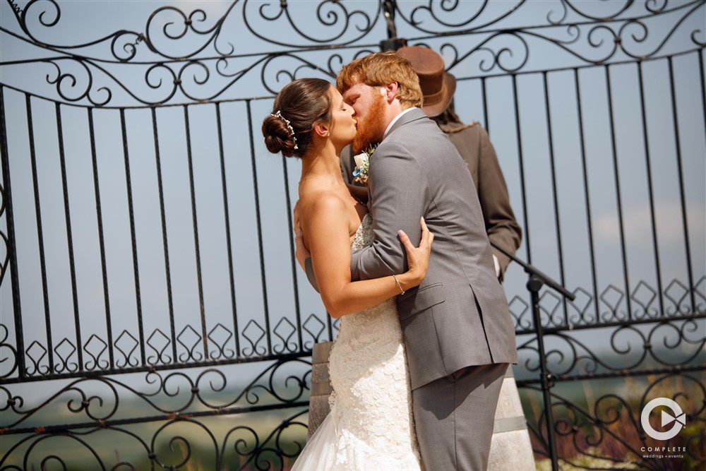 bride and groom kiss during the ceremony