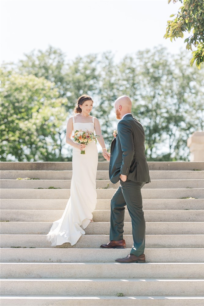 Bride and groom on steps at the Holland Center in Omaha NE with photographer Claire Katan