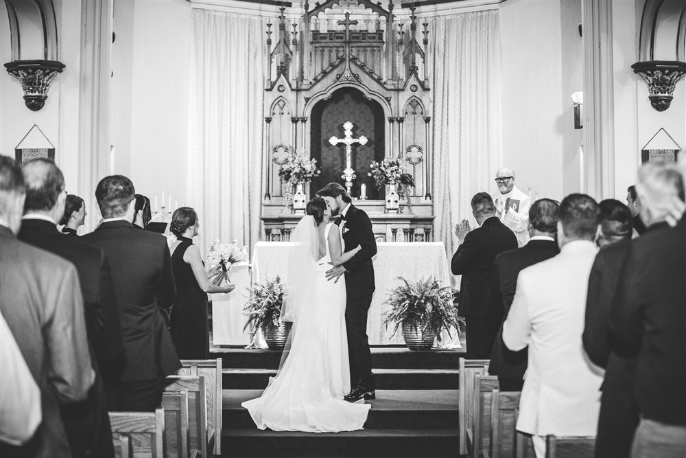 First kiss at the church before the reception at The Leo Ballroom in Omaha NE with photographer Katie Hammond