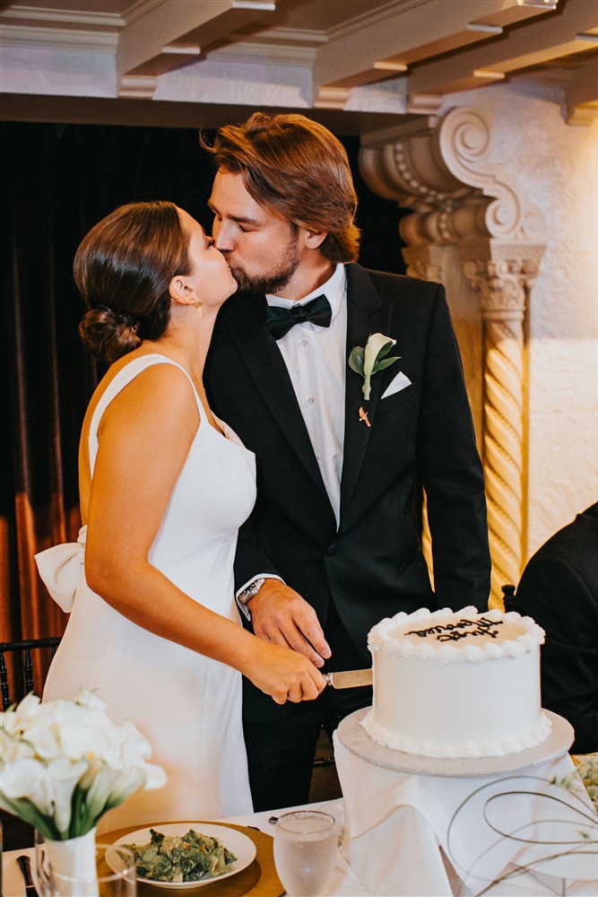 Bride and groom cutting the cake at The Leo Ballroom in Omaha NE with photographer Katie Hammond