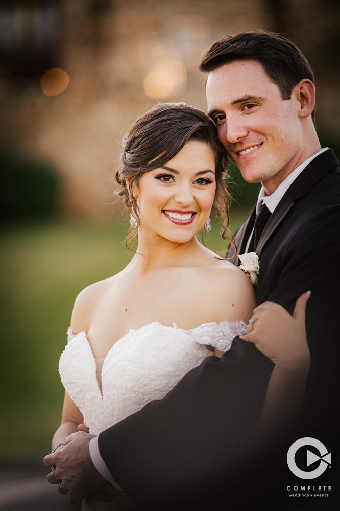 Groom holding bride in beautiful wedding photo bride smiles wide