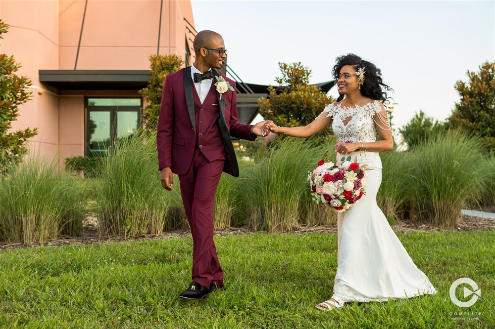 Wedding planner in Orlando | photography bride and groom holding hand and walking around ceremony location