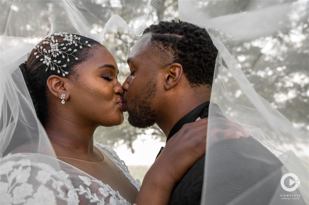 Tracey and AJ beautiful veil shot kissing at Lake Mary Events Center October wedding
