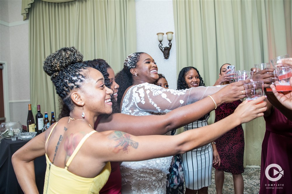 Bride cheers with her bridesmaids and friends at her Lake Mary wedding reception