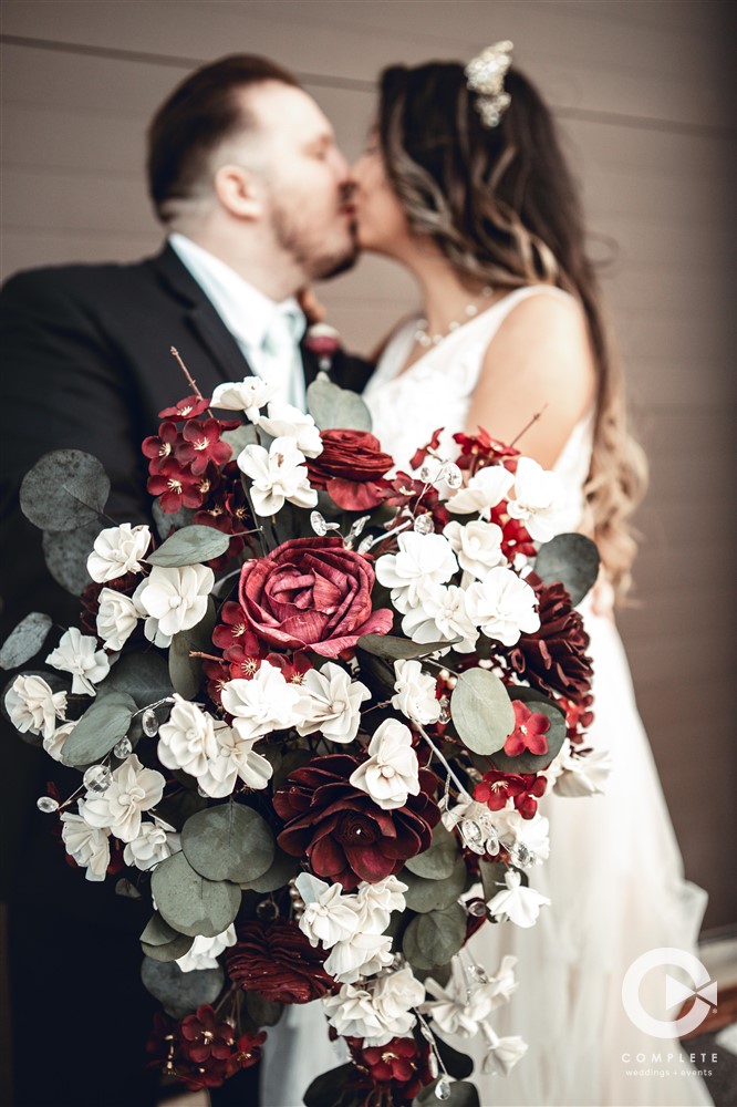Bride and groom holding a bouquet during their Fall wedding in Lake Nona