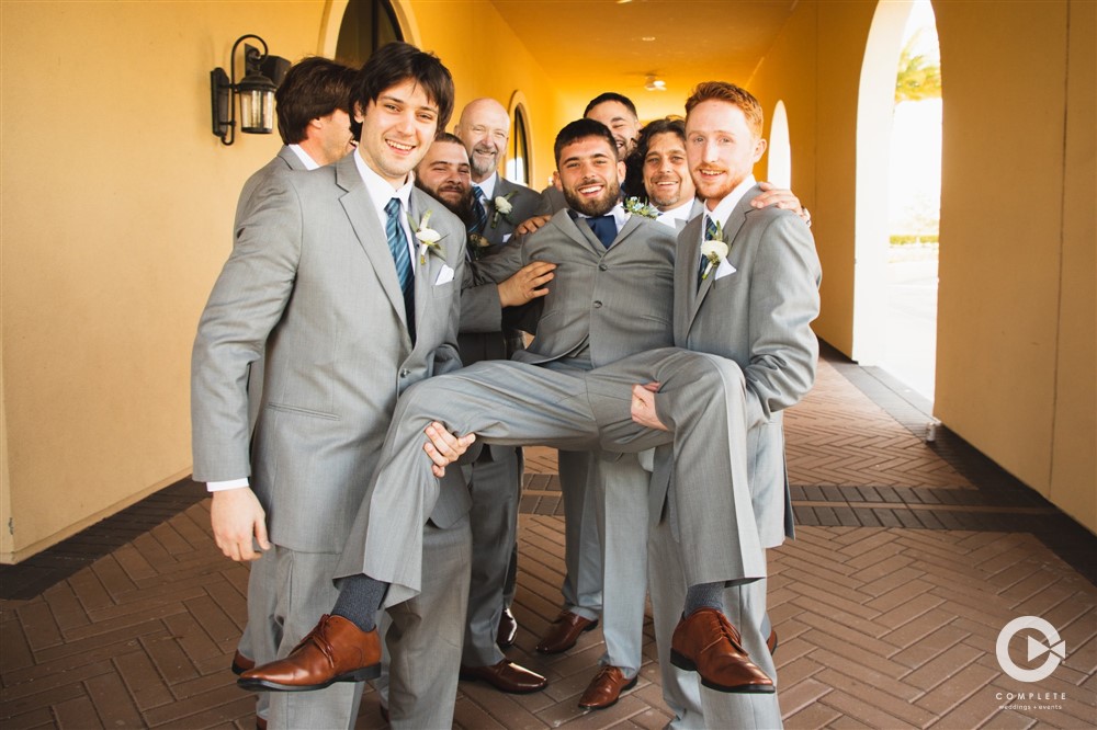 Groomsmen carrying groom at The Omni Resort Orlando during January wedding