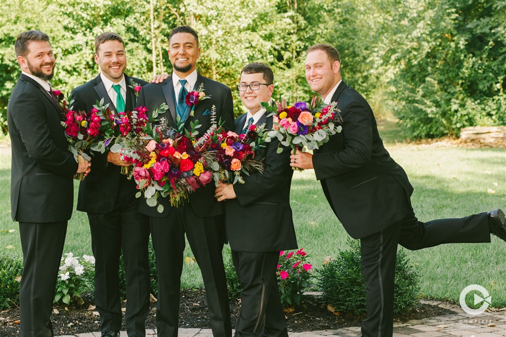 groomsmen holding colorful bouquets