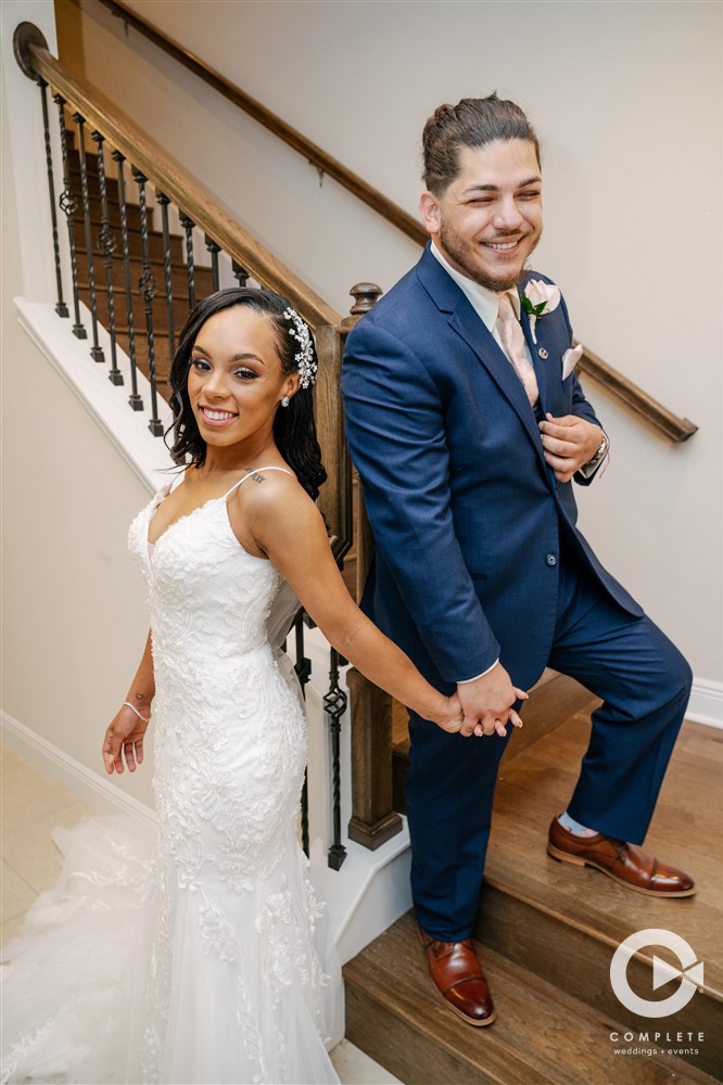 Bride and groom holding hands on the stairs at Paddlefish