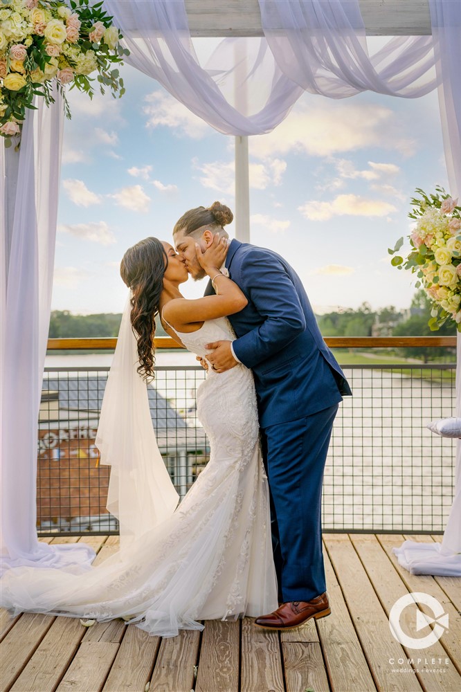 Disney Springs Wedding | Bride and groom kissing at the altar during wedding ceremony