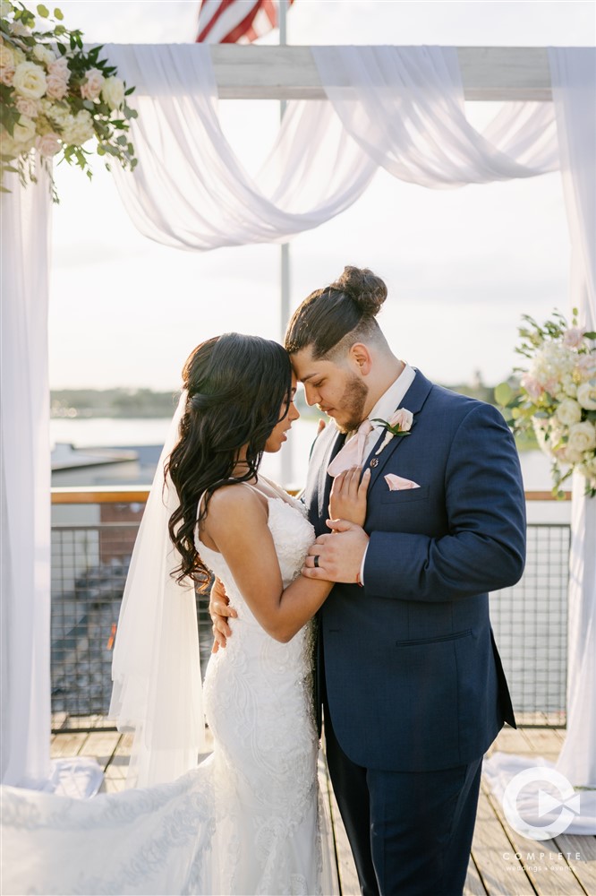 Disney Springs Wedding | Bride and groom holding each other near the altar of the ceremony