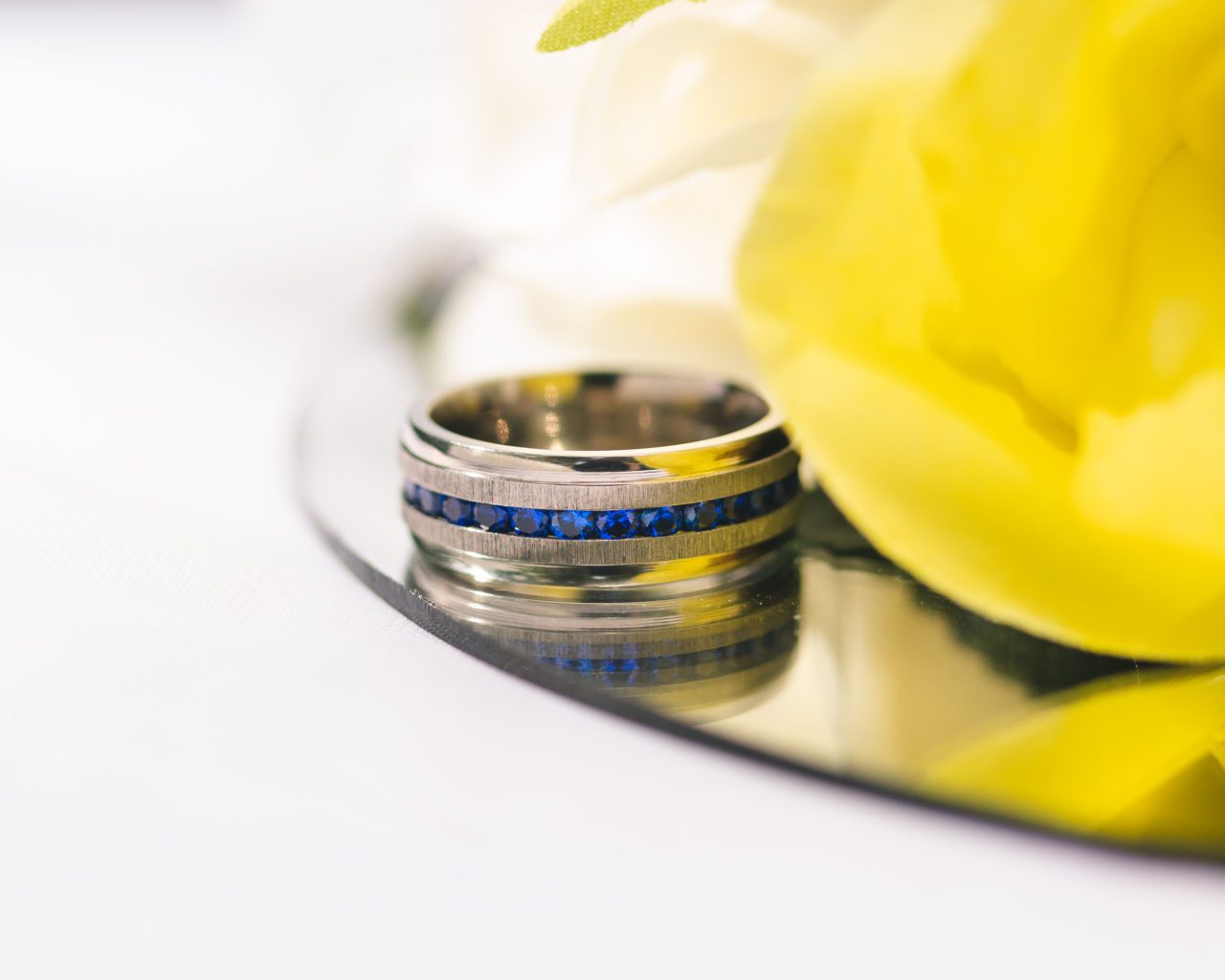 Beautiful wedding ring detail shot with yellow accent in top left of shot taken by Gabriel Evans