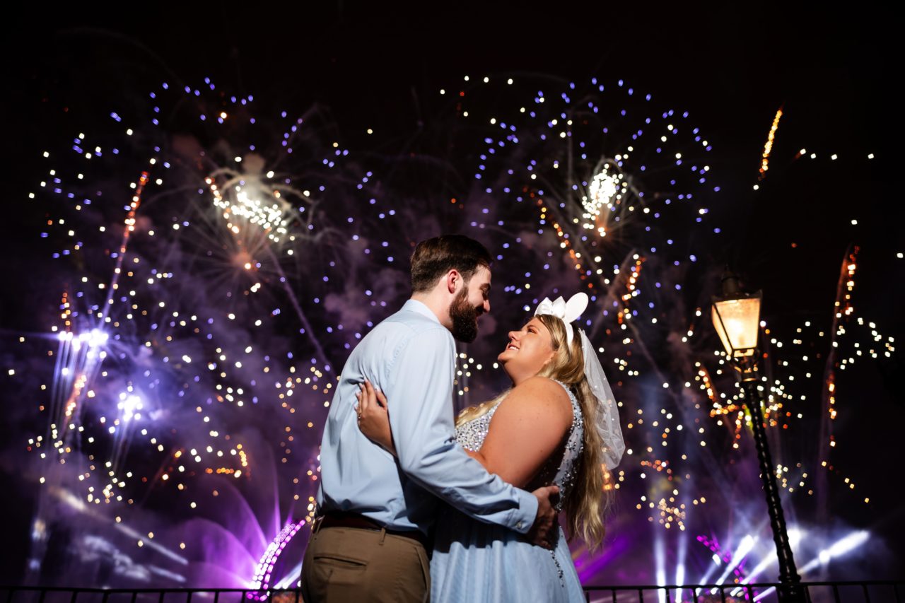 Disney wedding photo with fireworks going off behind the Orlando couple