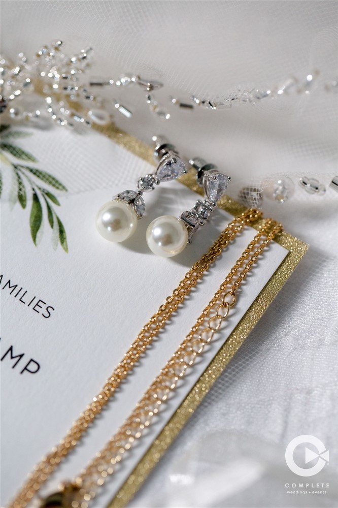 Earrings set out on top of a wedding invitation amazing detail photo at a Highland Manor wedding