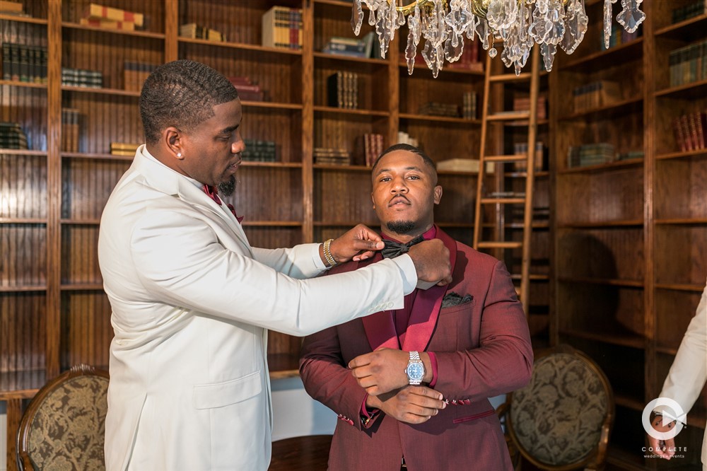 Groom getting ready for wedding day with best man's help