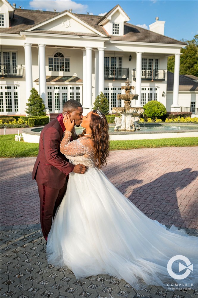 Bride and groom kissing outside of venue at Luxmore Grande Estate