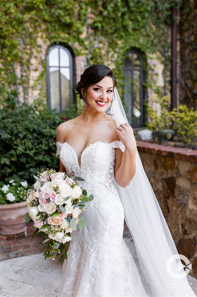 Bride smiling with her wedding veil flowing behind her