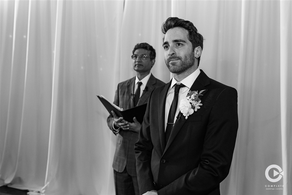 Groom watching his bride walk down the isle towards him at their wedding ceremony gorgeous wedding moment between bride and groom