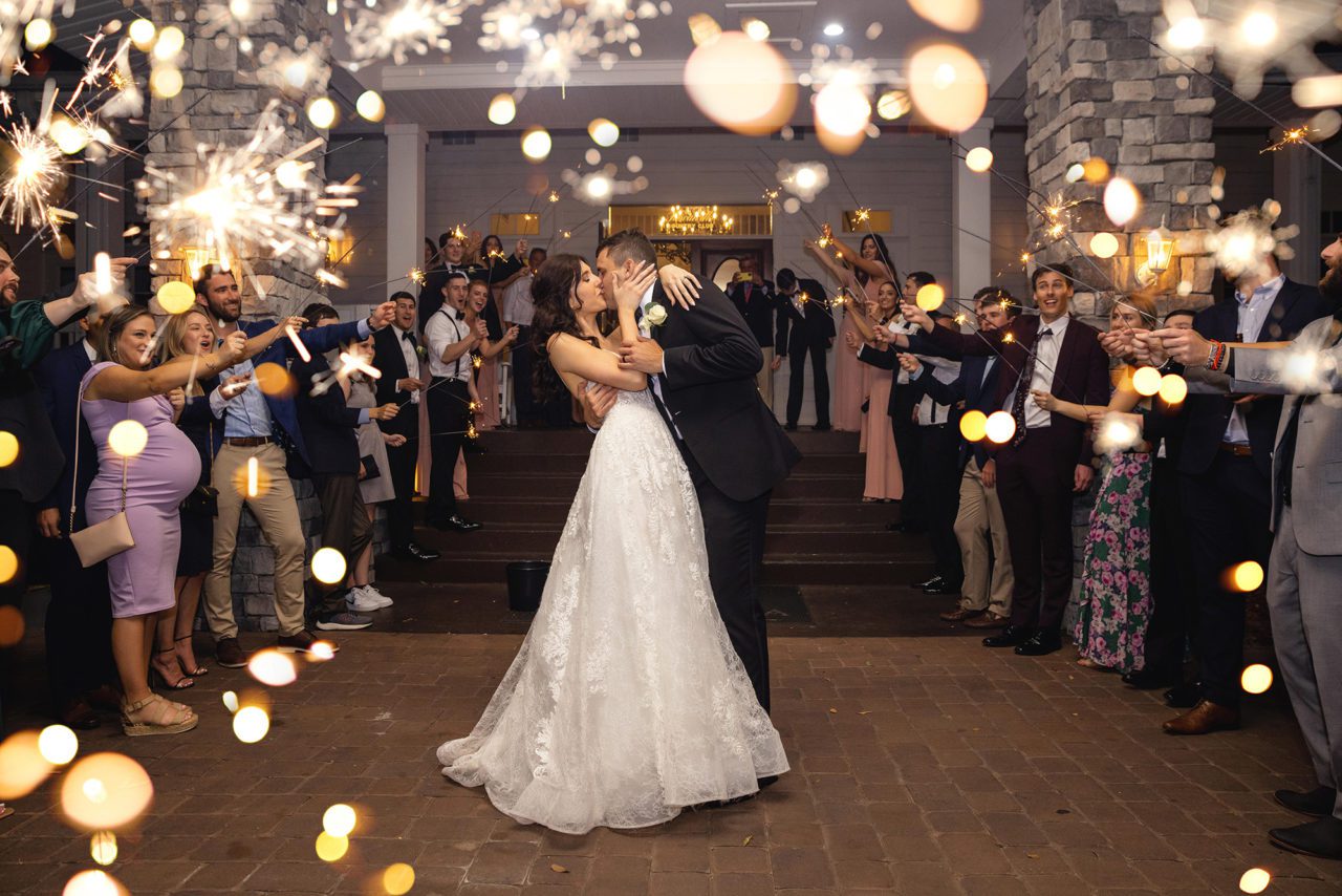 Wedding couple with sparkler exit sparks showing around camera lens