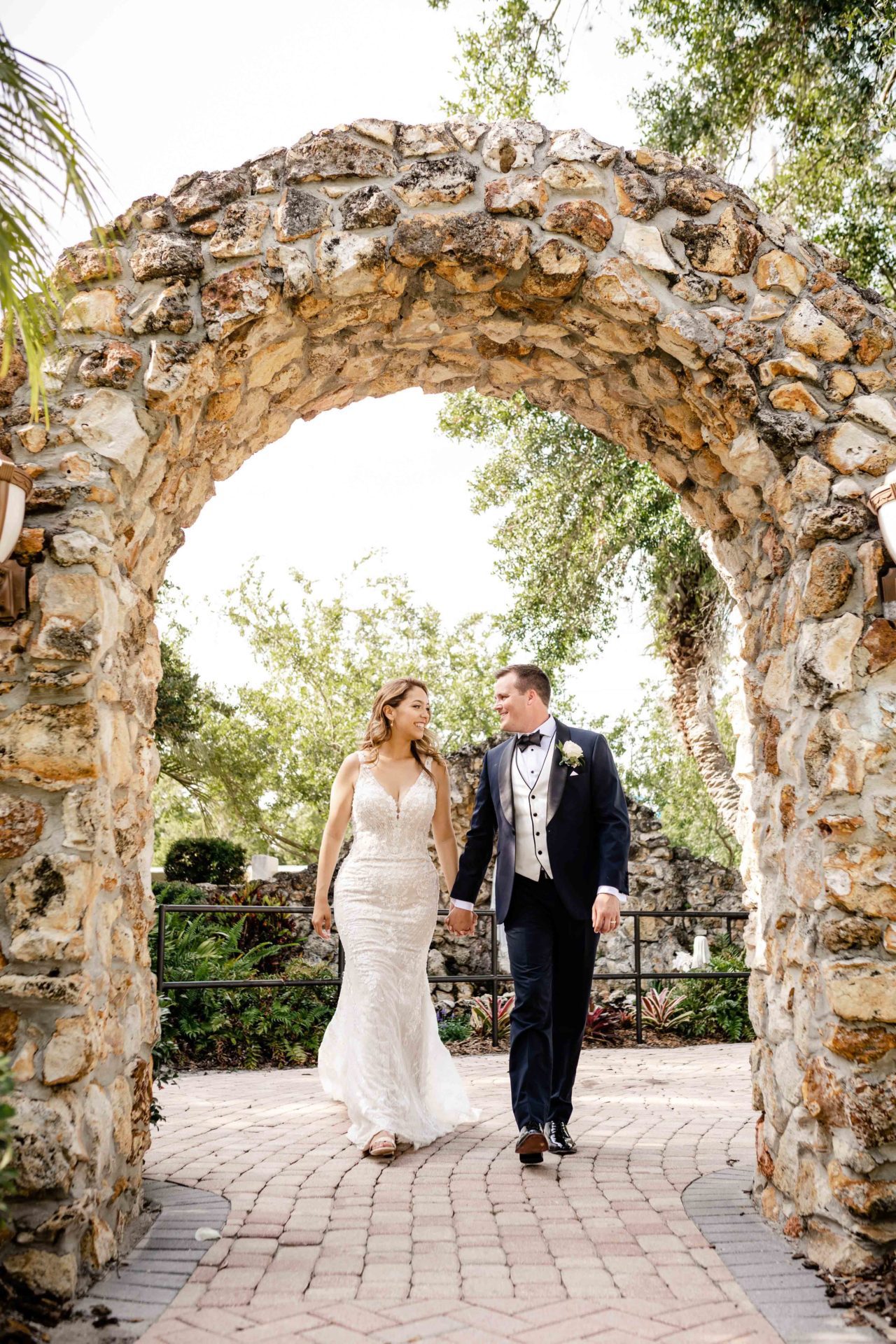 Gorgeous wedding in May Orlando Florida walking through stone arch