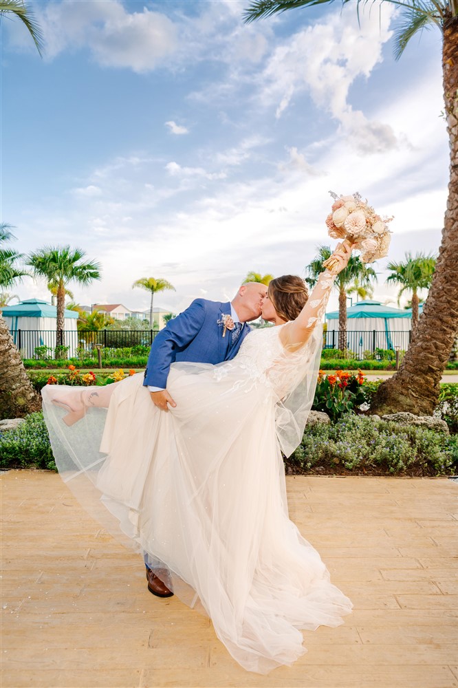 Bride and groom kissing while groom dips his bride at their Margaritaville Orlando wedding reception