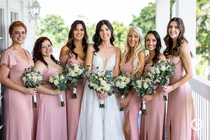 Bride and her bridesmaids on wrap around porch at Tuscawilla Country Club