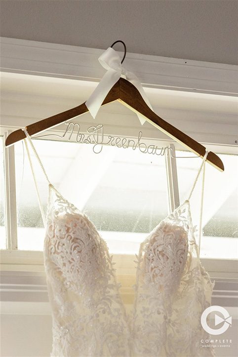 Brides dress hangs on hanger with new last name at Tuscawilla Country Club in Orlando, FL