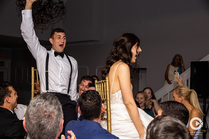 Couple lifted in chair at Tuscawilla Country Club wedding