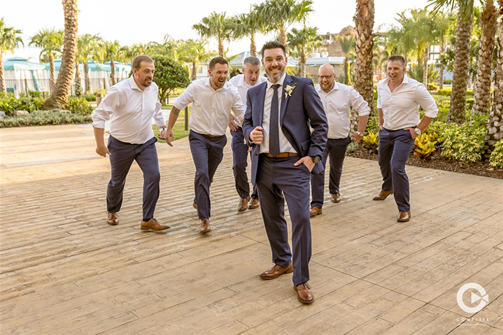 Groomsmen running to hug the groom in Orlando, FL