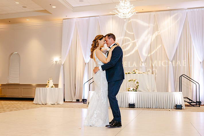 Bride and groom share first dance with monogram light in Orlando, FL