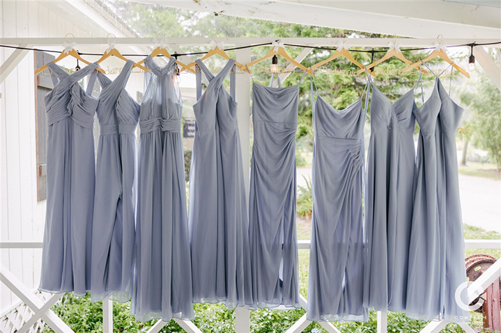 Powder blue bridesmaid dresses hung all in a row at The Mulberry