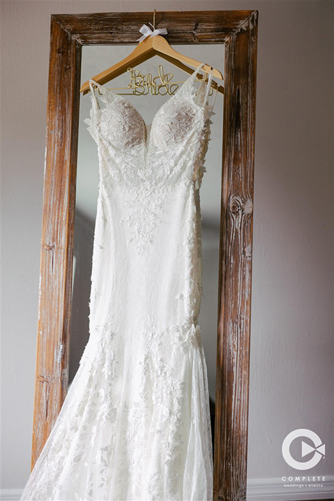 Bride's wedding dress hung up for detail photo in New Smyrna Beach, FL