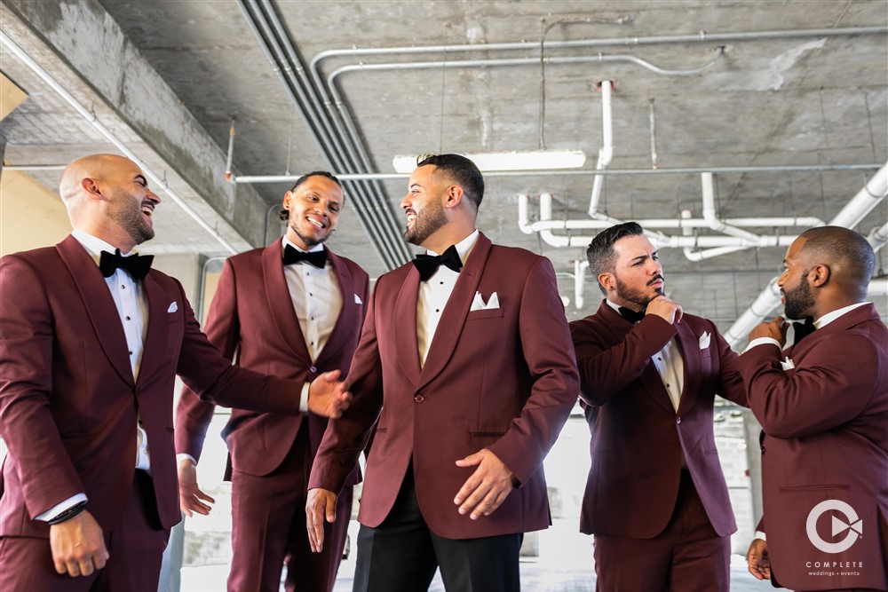 Groomsmen walking into their reception hall amazing wedding photo red suits.