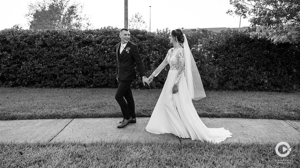 Bride and groom walking together holding hands during their wedding reception at The Acre Orlando