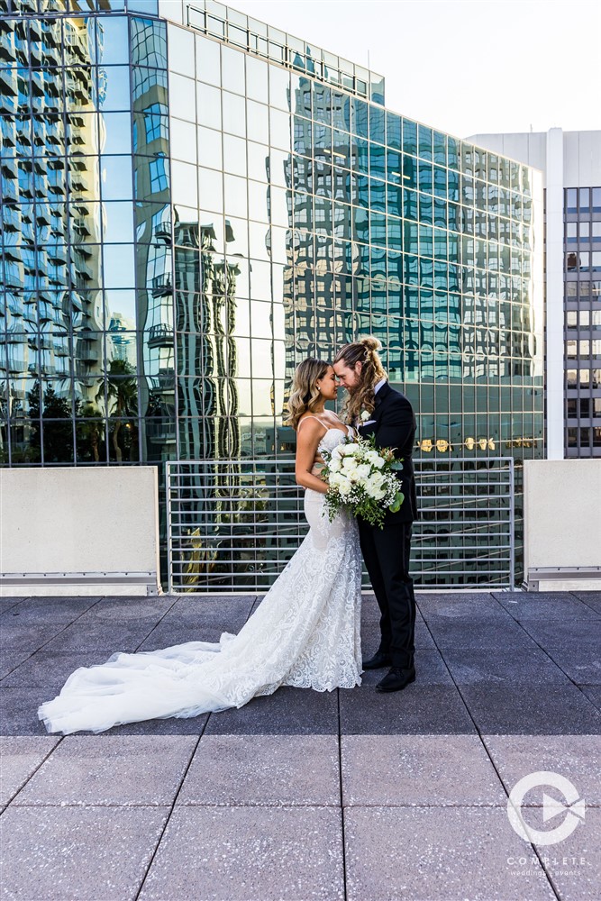 Wedding couple at The Balcony in Downtown Orlando around large buildings