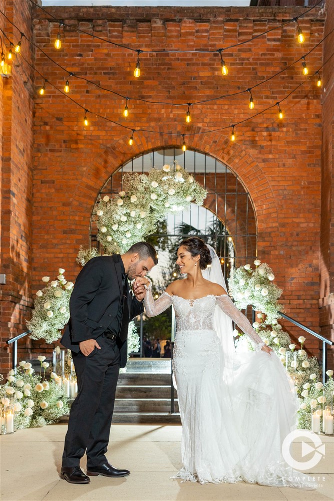 Wedding shot by Complete Weddings + Events at Venue 1902 unique shot with market lights above the couple.