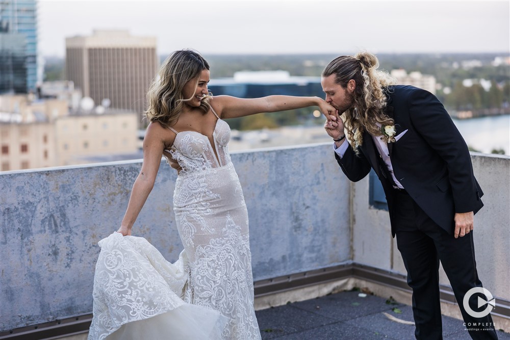 Groom kissing his bride's hand during their wedding reception at The Balcony Orlando