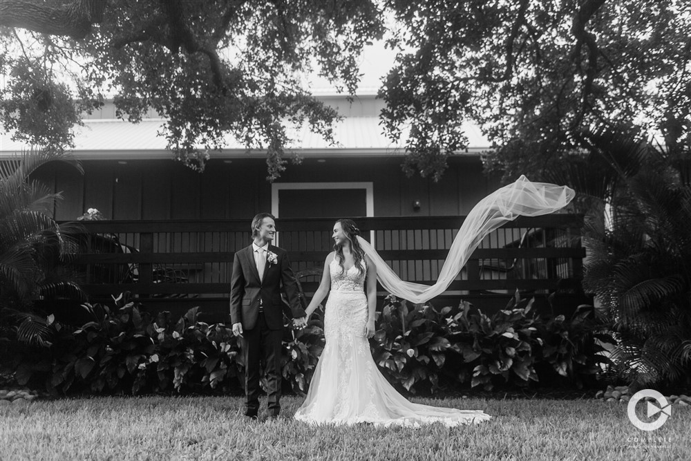 Bride and groom stand outside their wedding reception at The Grand Ol' Barn in New Smyrna black and white wedding photo