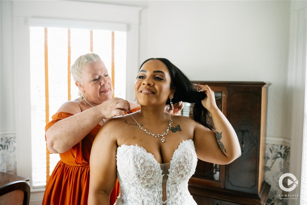 bride putting on jewelry