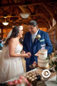 bride and groom cutting cake and laughing