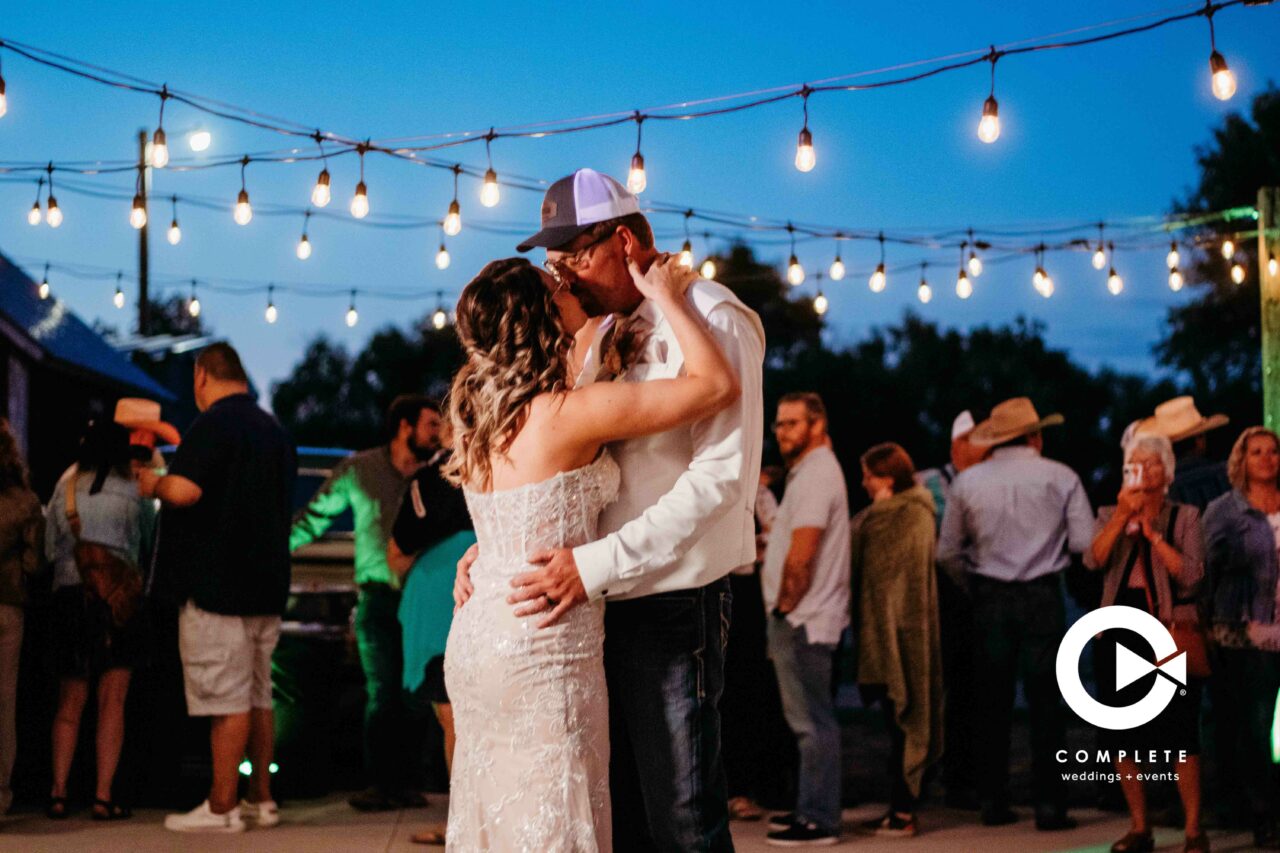 Bride and groom kissing on the dance floor during first dance