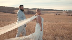 Bride and groom walking through a field