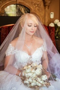 beautiful bride wearing bridal veil and holding her wedding flowers