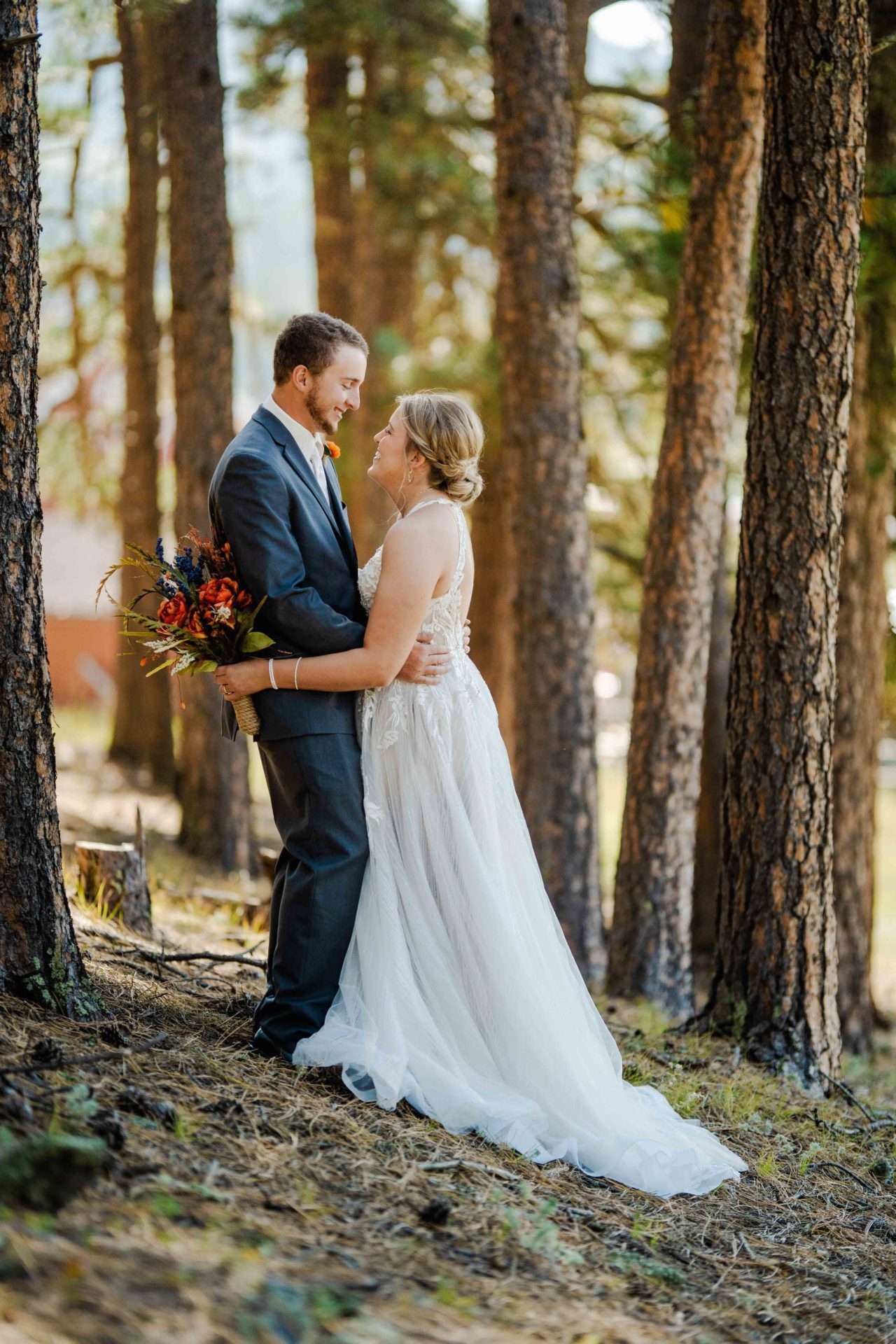 bride and groom standing in the woods - destination wedding